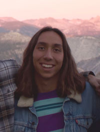 Luke Seidman pictured in front of rolling hilltops and mountains