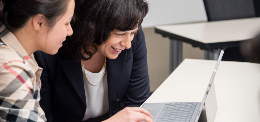 Seaver faculty professor looking at a computer screen next to a female student