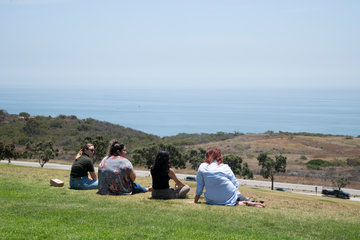 Students seated at the edge of Alumni Park