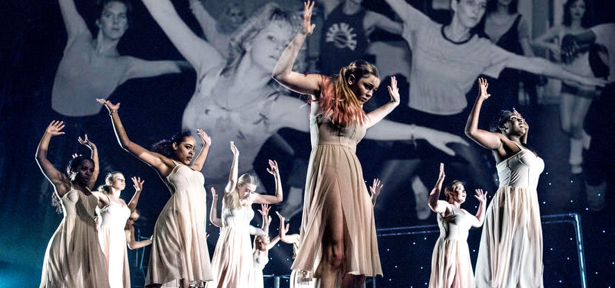 Seaver students dressed in white performing on stage for Dance in Flight