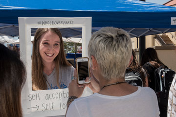 Student holding a sign that says "Self-Acceptance"